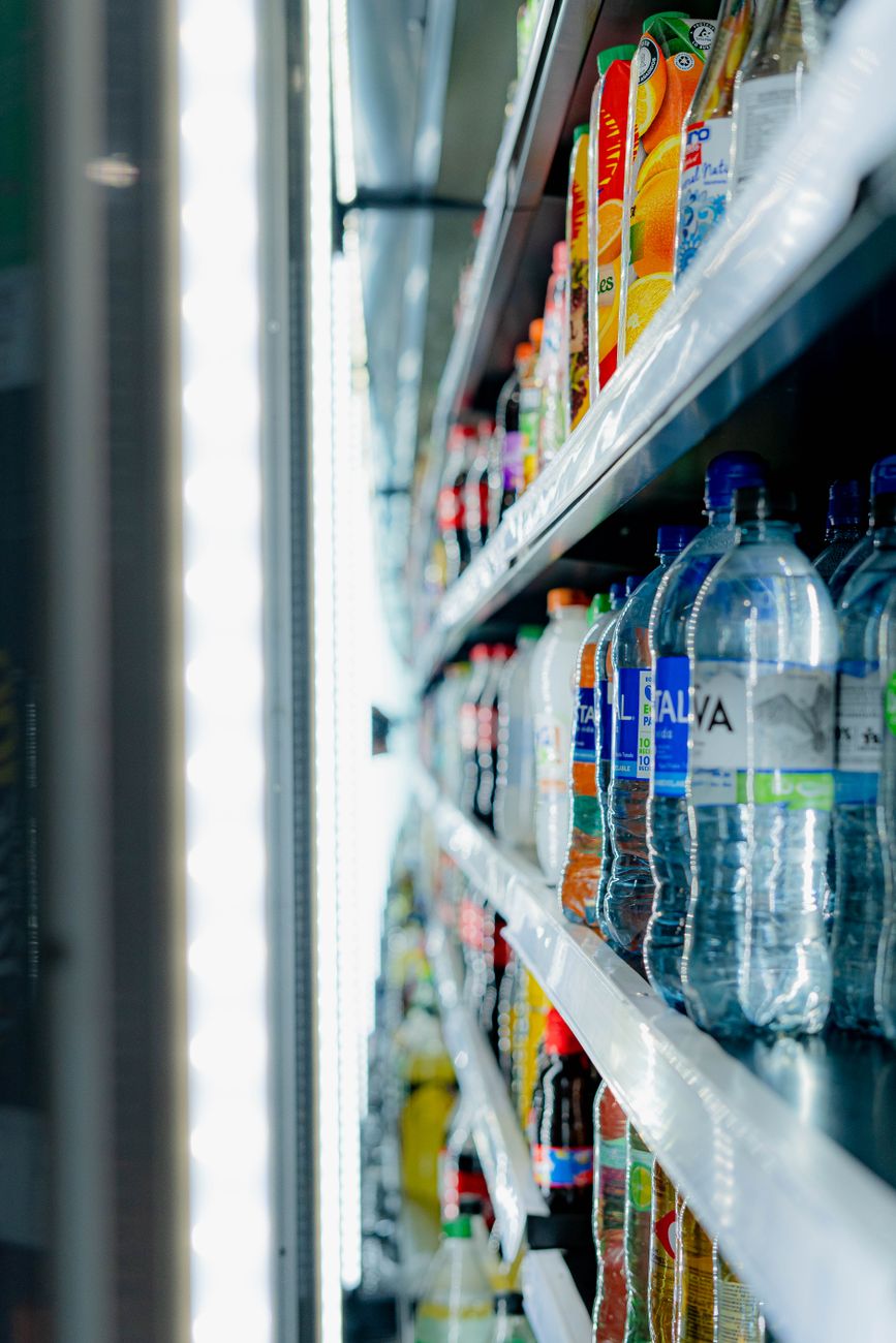 Assorted chilled beverages neatly arranged in a grocery store display cooler.
