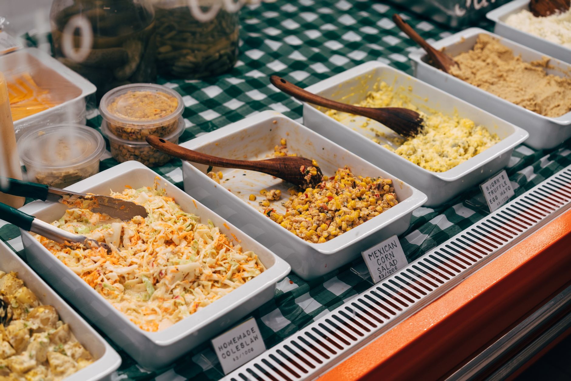 A variety of salads including coleslaw, corn salad, and more at a buffet in Singapore.