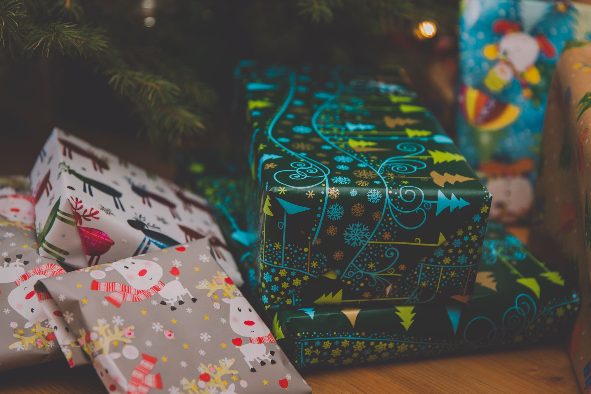 Festive Christmas presents with colorful wrapping paper under a decorated tree.
