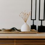 white ceramic vase near two black table decors