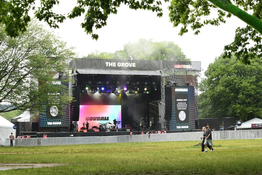 A band is performing on a stage outdoors.