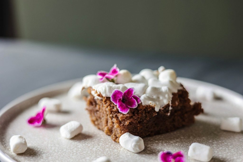 a piece of cake on a plate with marshmallows