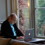 man in black suit jacket using macbook