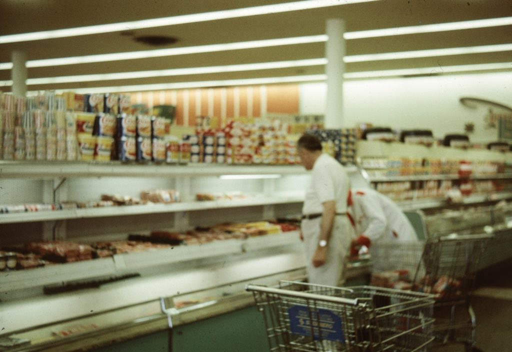 a man in a grocery store with a shopping cart