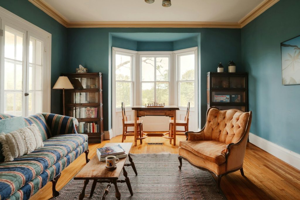 Teal living room with striped sofa and orange armchair