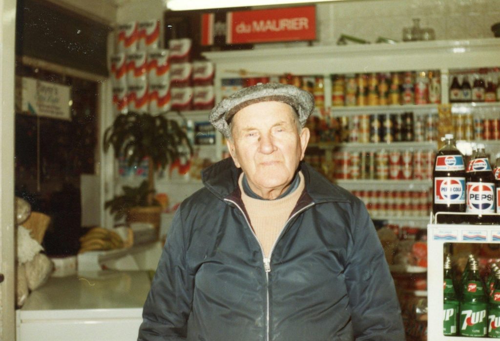 Elderly man wearing a cap and jacket in a store.