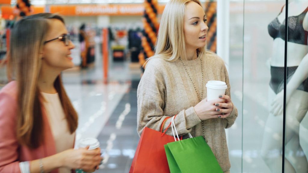 Two women looking at a store window display