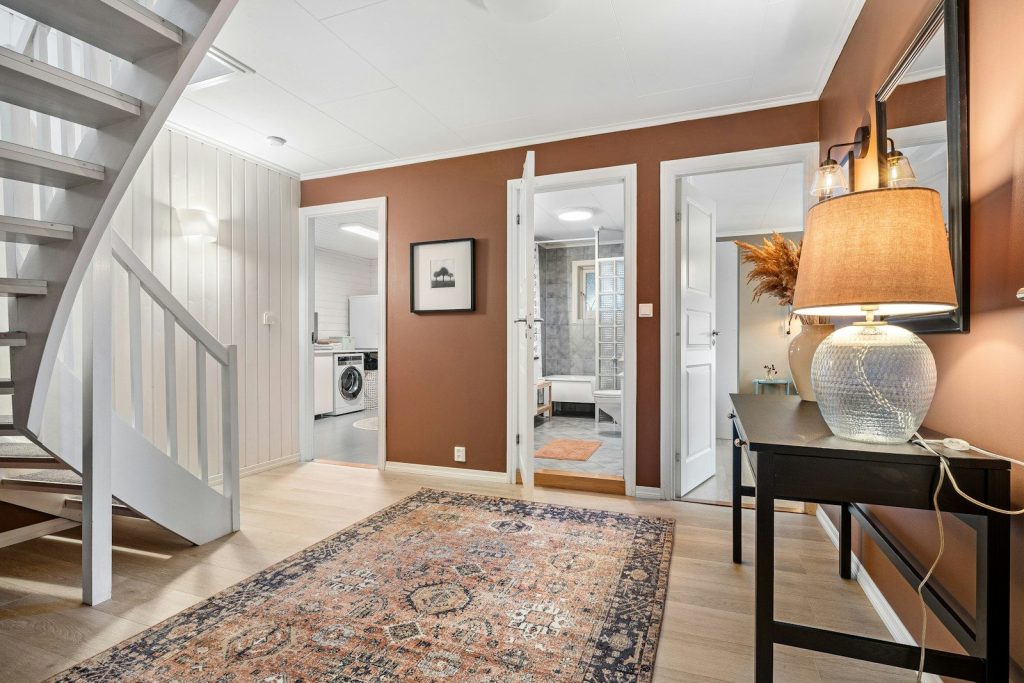 A living room with a stair case and a rug