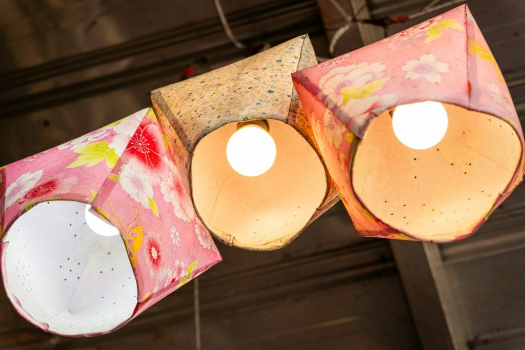 Three decorative paper lanterns illuminated indoors