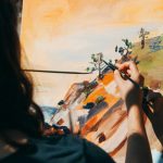 woman painting tree and cliff