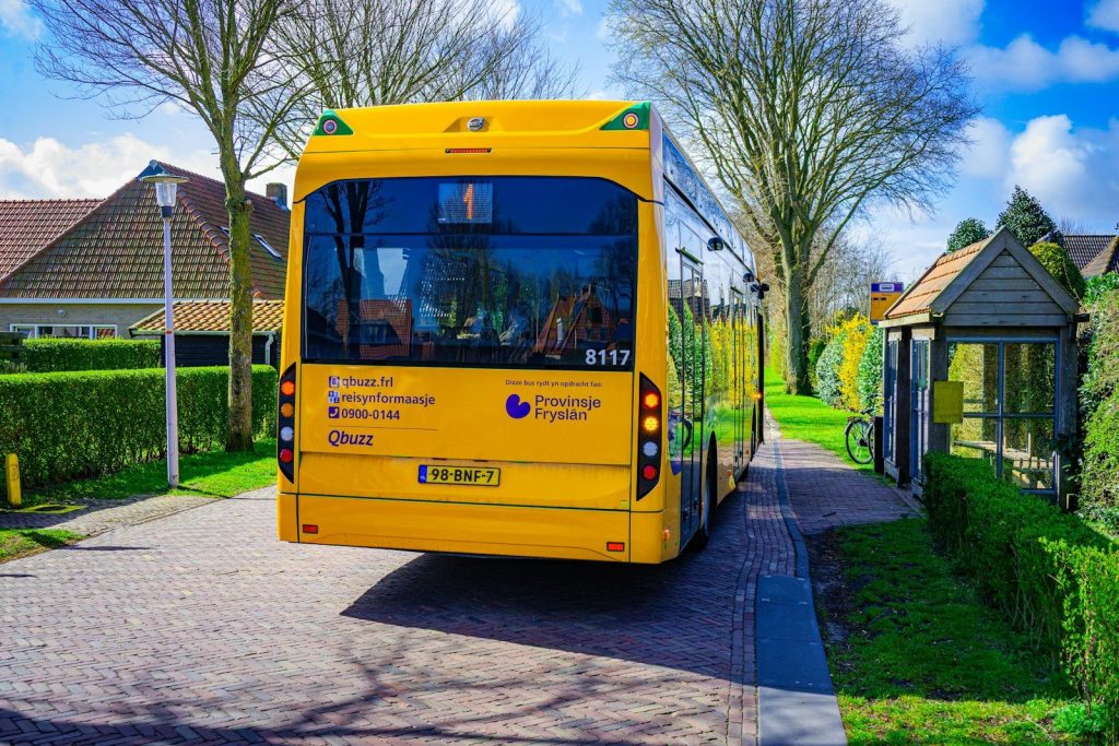Yellow bus parked at a suburban bus stop.