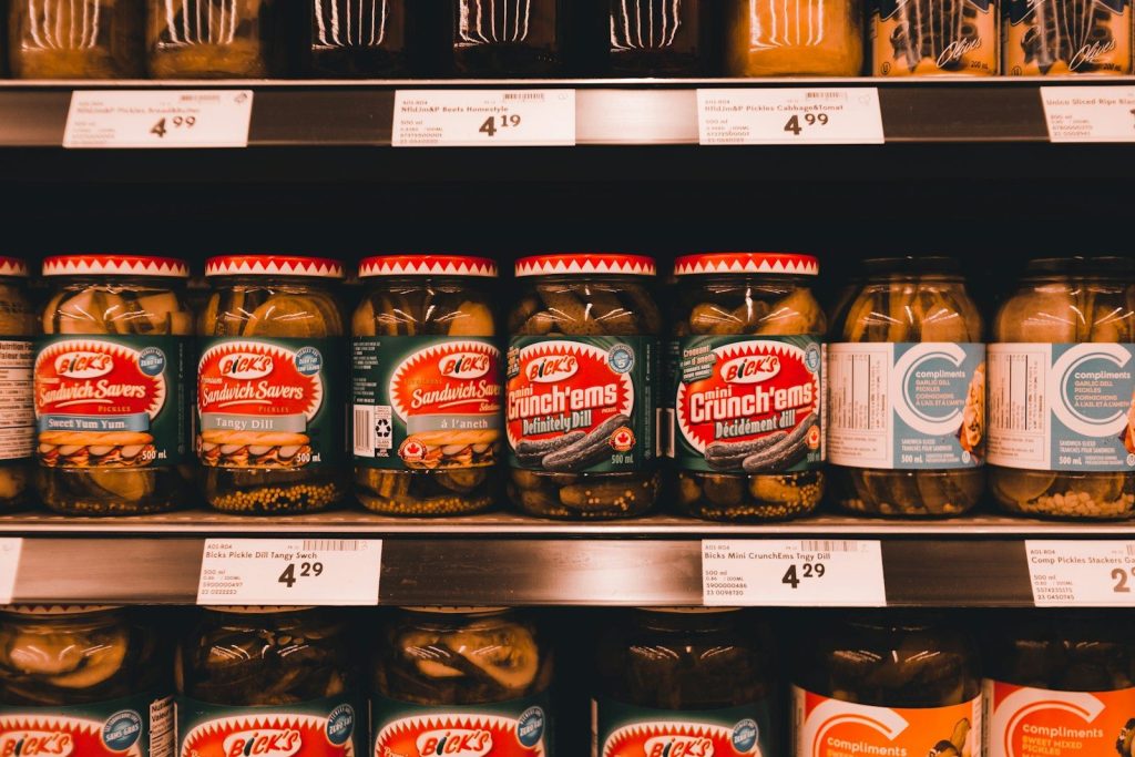 jars of pickles and other food items on a shelf