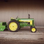 a green and yellow tractor parked in front of a building