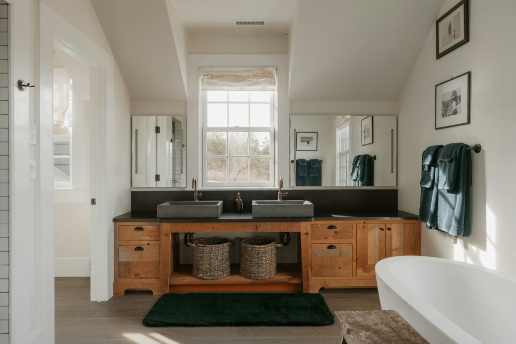 A modern bathroom with double sinks and a bathtub.