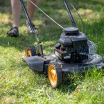 a person mowing the grass with a lawn mower