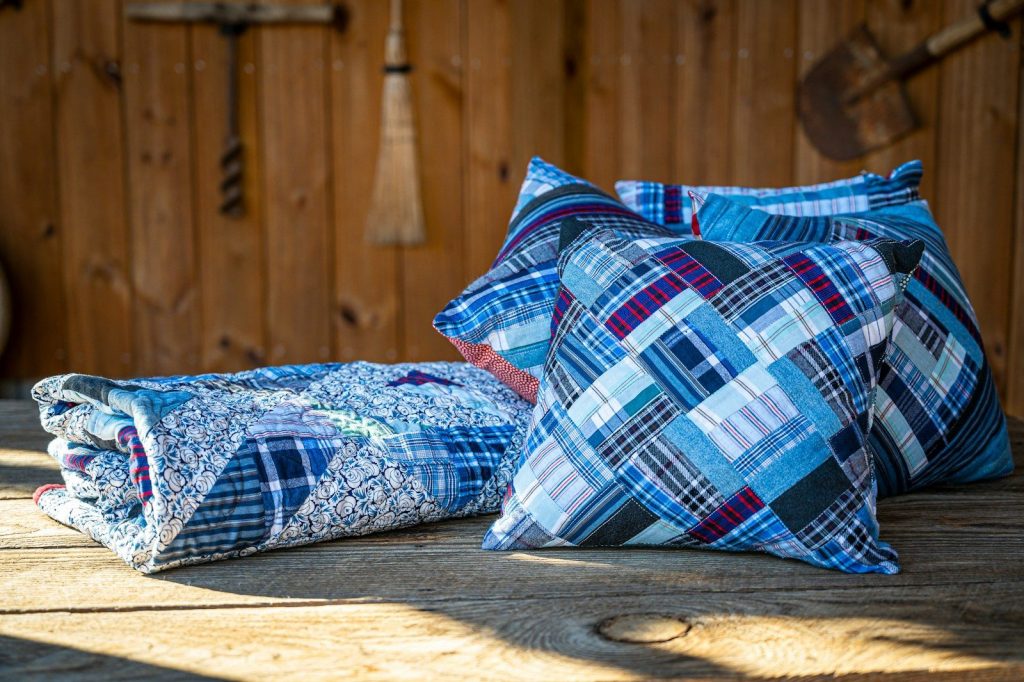Blue patterned pillows and a quilt are shown.