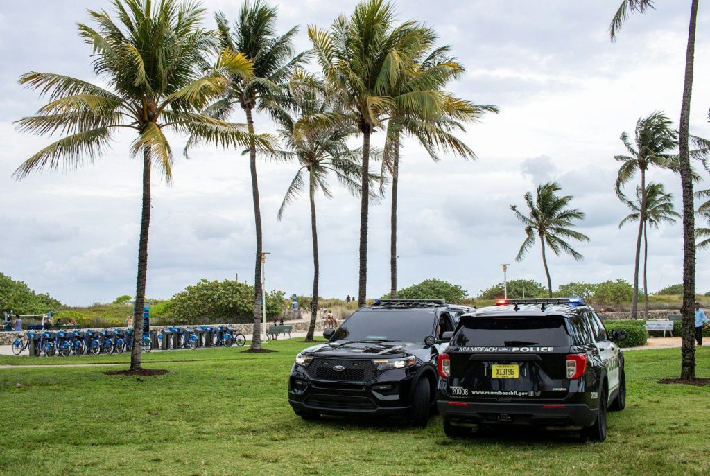 A couple of cars parked next to each other on a lush green field