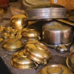 a table topped with lots of brass pots and pans