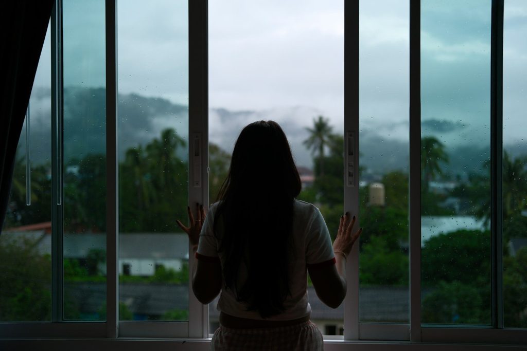 A woman looks out at a foggy mountain view.