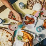 a group of people sitting around a table with food