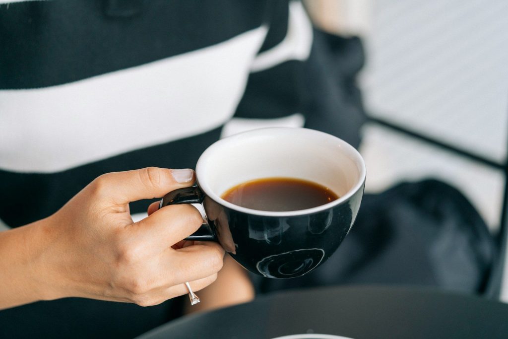 a woman is holding a cup of coffee