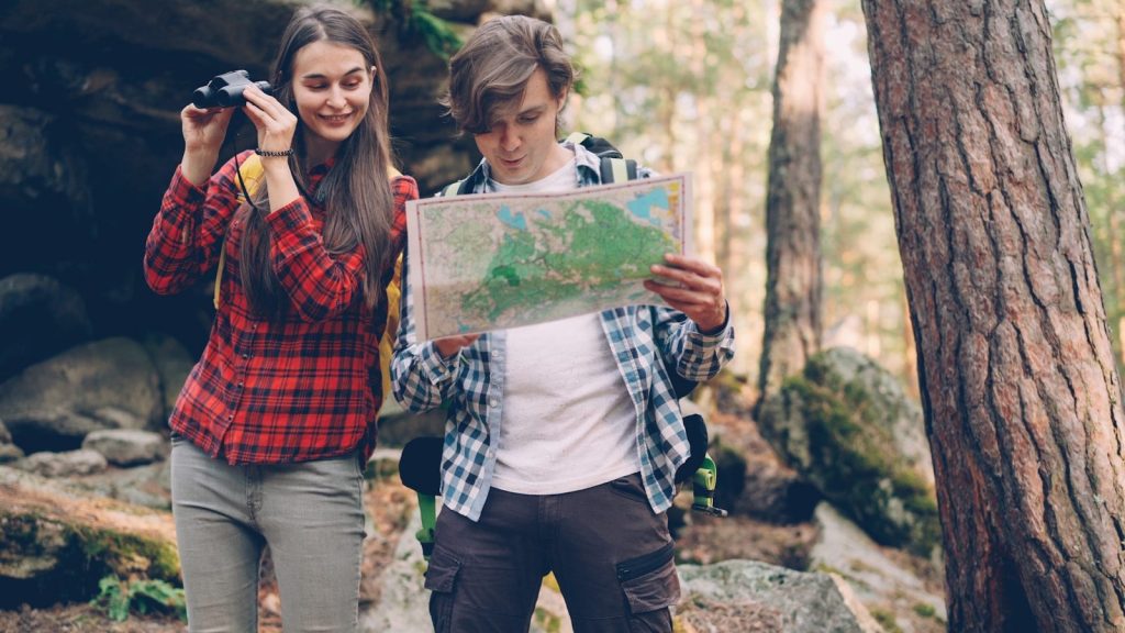 Couple looking at map in forest