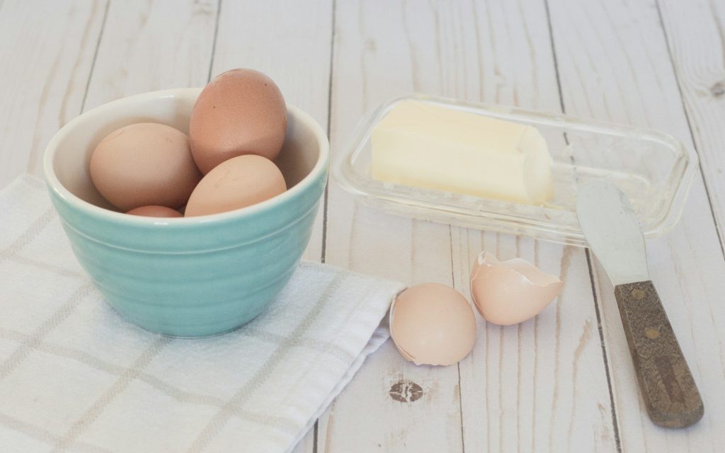 a bowl of eggs and a knife on a table