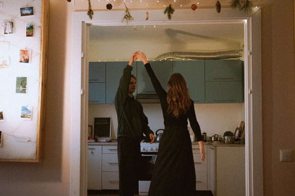 Couple dancing in a kitchen with fairy lights