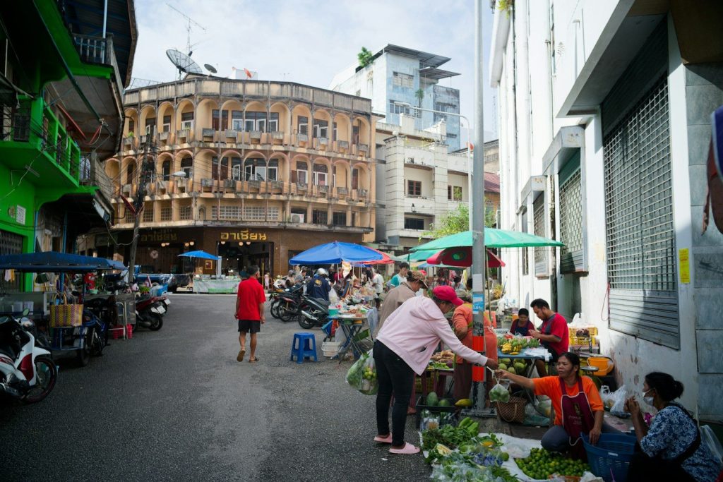 People shopping at a bustling outdoor market street.