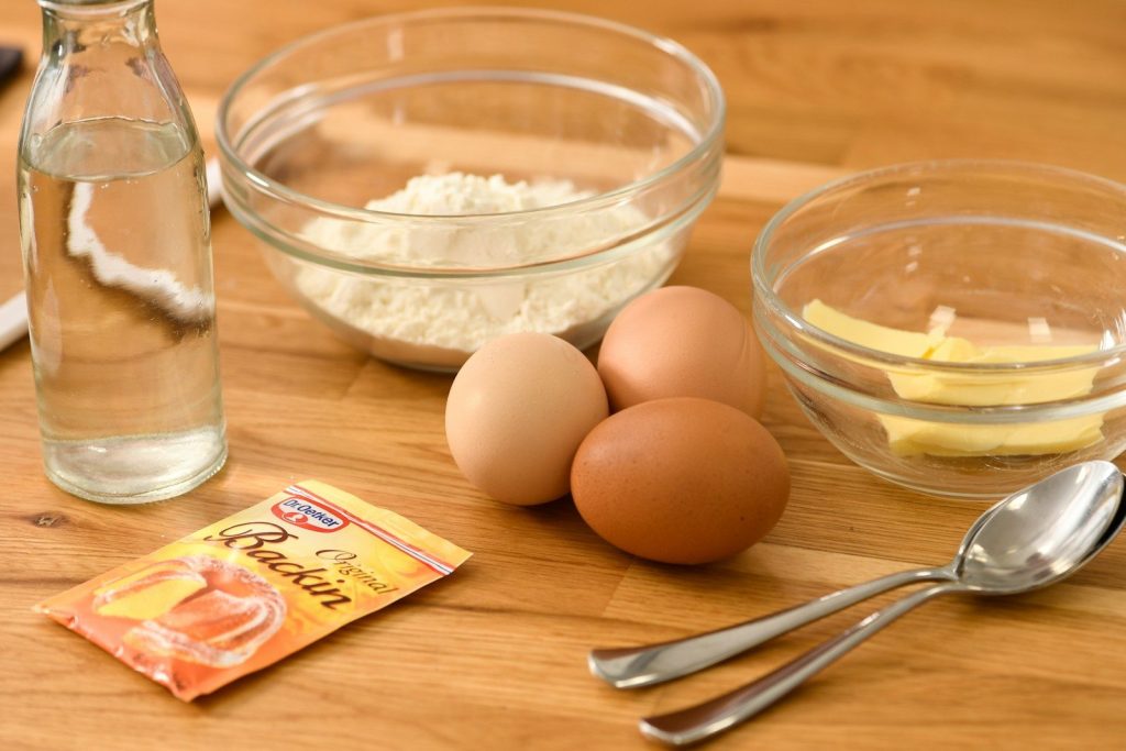 brown eggs on clear glass bowl beside stainless steel fork