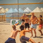 Men playing beach volleyball on a sunny day