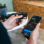 a person holding a smart phone and a credit card