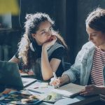 Two women are working together on a project.
