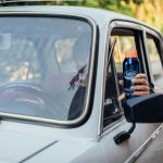 a person holding a bottle of water in a car