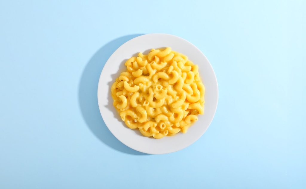 Mac and cheese served on a white plate.