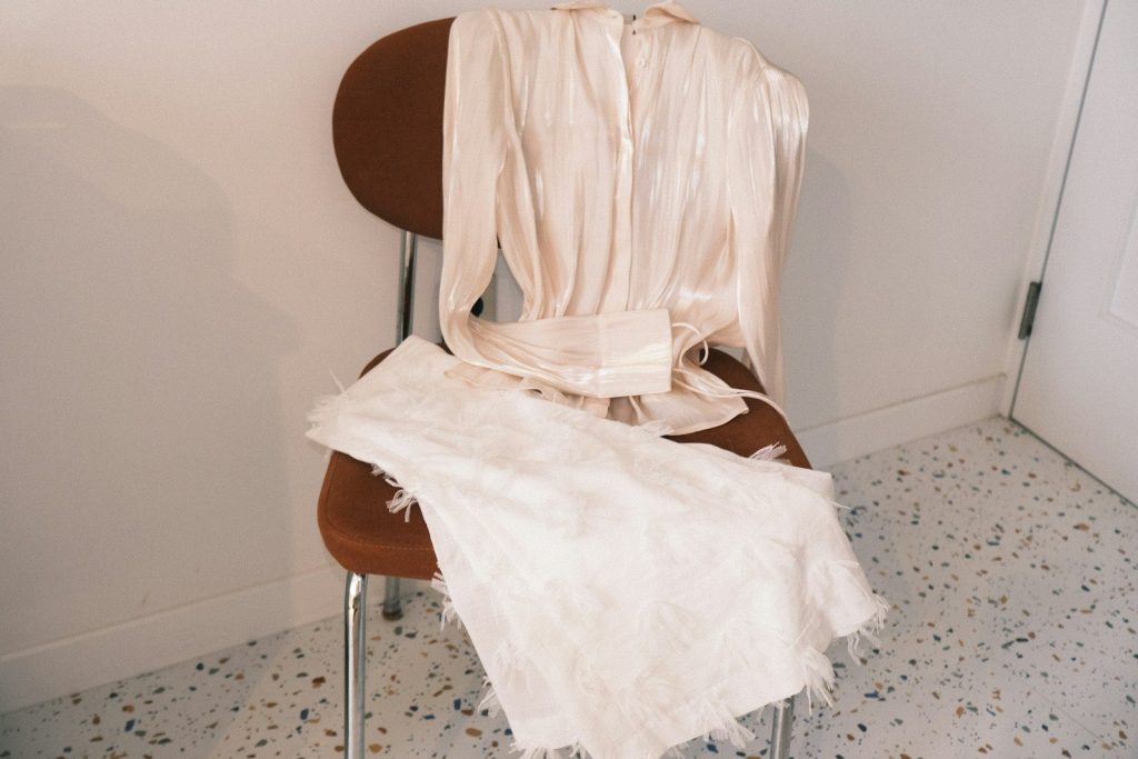 A cream-colored dress draped over a chair
