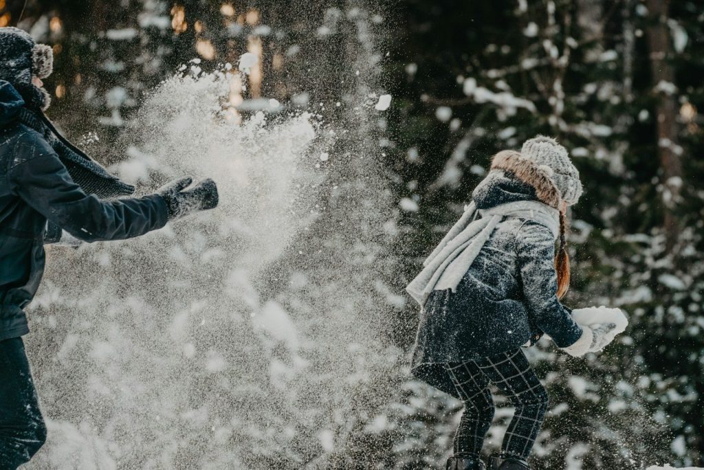 a man and a woman playing in the snow