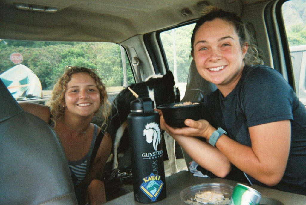a couple of women sitting in the back of a van