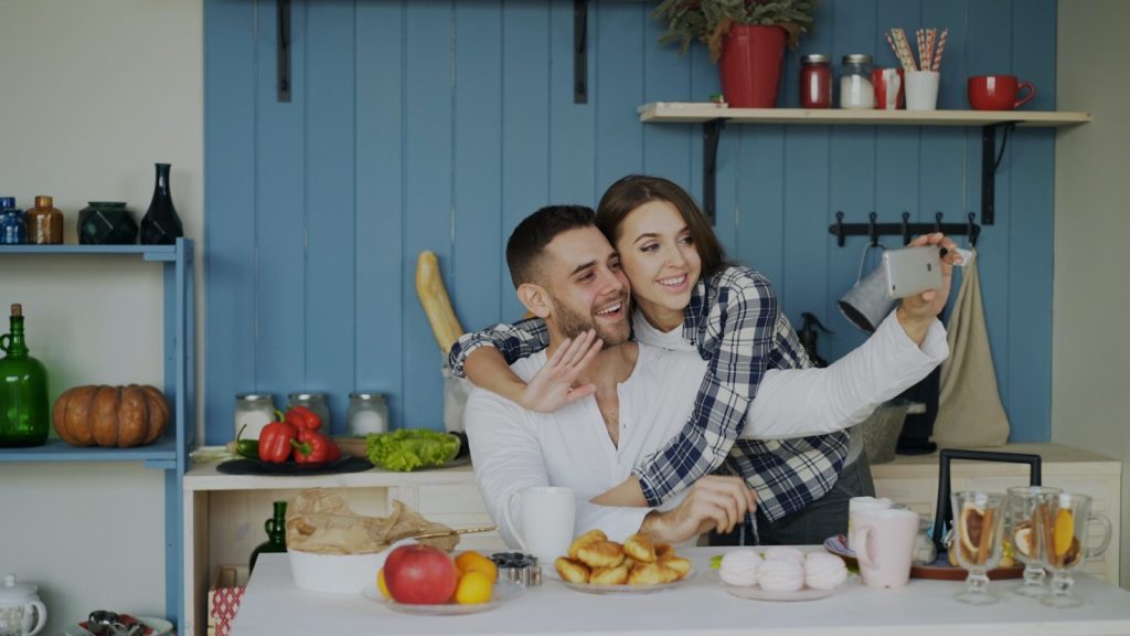 Couple taking a selfie in a kitchen during breakfast