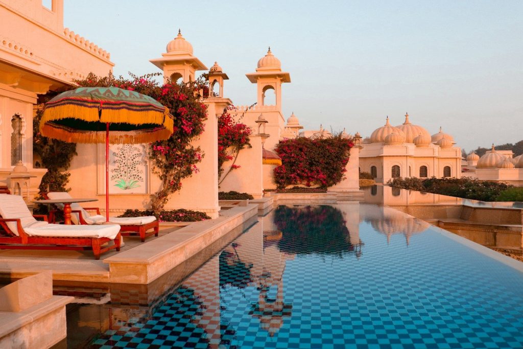 A large swimming pool with a lounge chair next to it