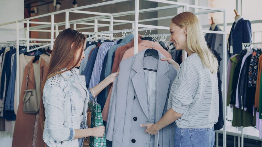 Two women shop together in a clothing store.