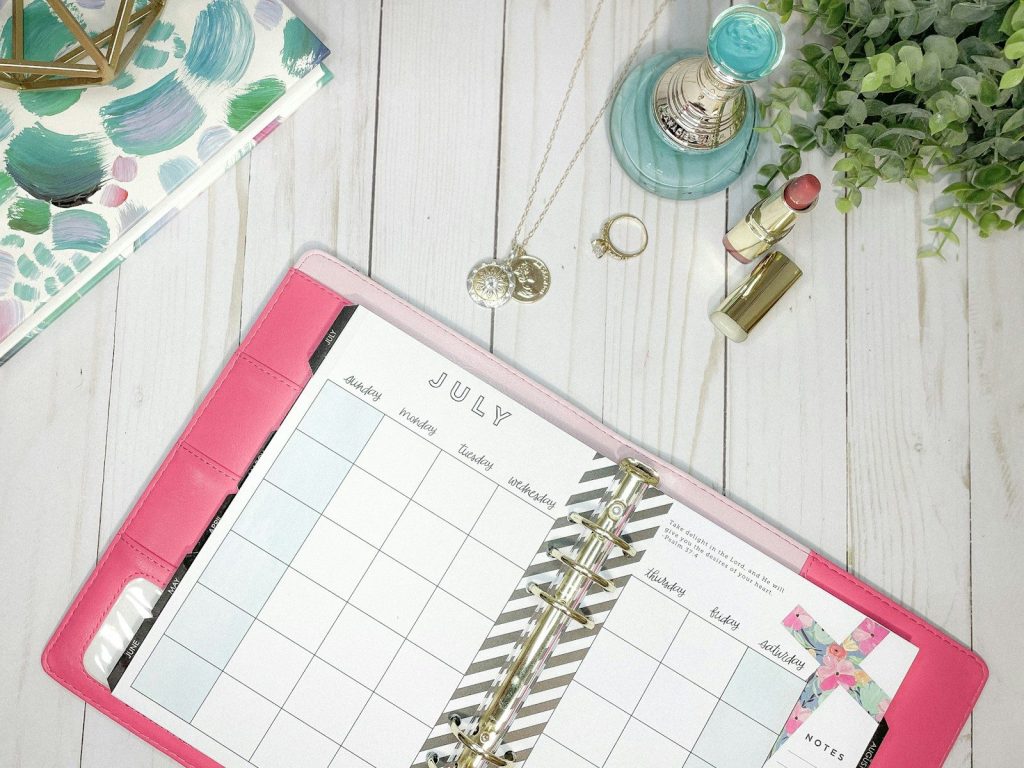 white and pink spiral notebook