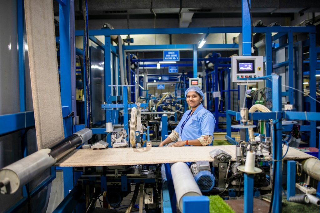 Woman operates industrial machinery in a factory.