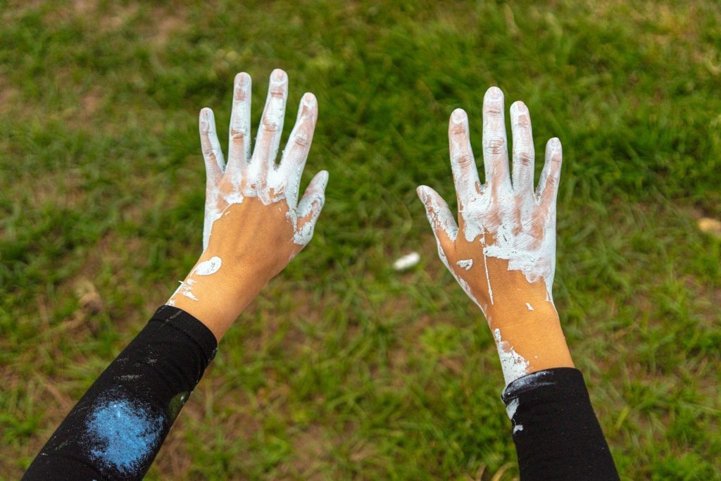 Hands are covered in white paint.