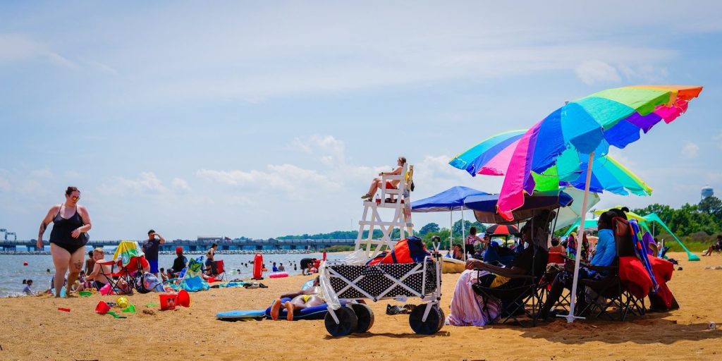 People enjoying a sunny day at a busy beach.