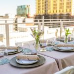 Rooftop dinner table is set, ready for guests.