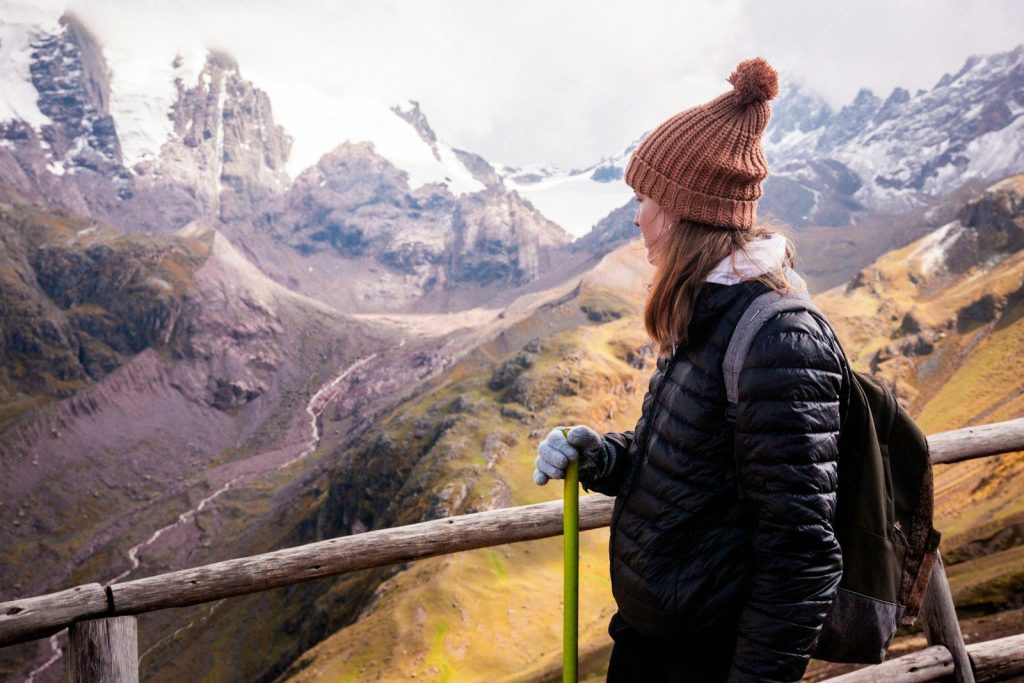 a woman standing on top of a wooden fence