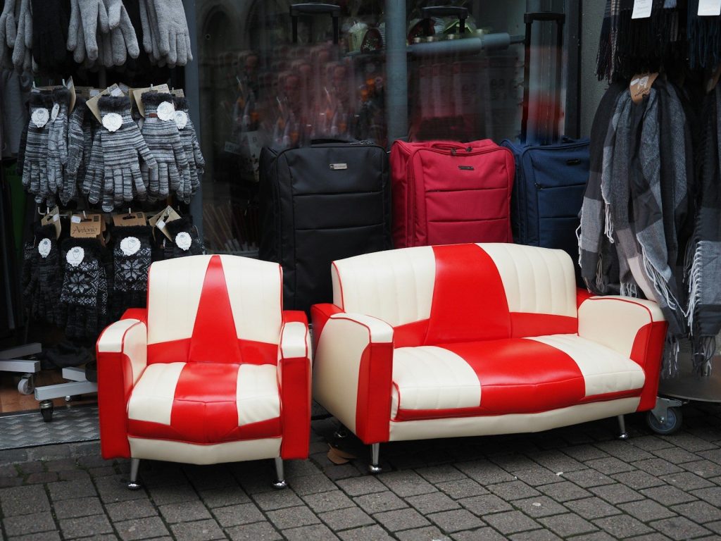 Red and white striped sofa and armchair outside a store.