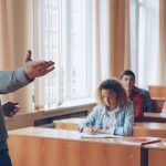 Professor lecturing to students in a lecture hall.