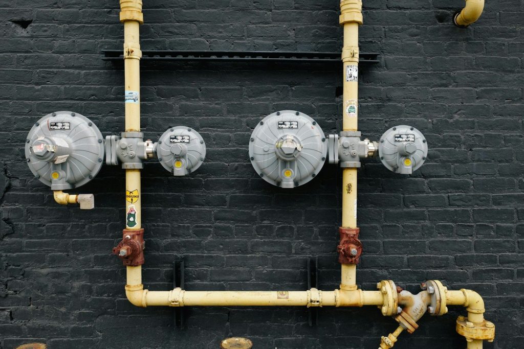 Pipes and equipment are mounted on a black wall.